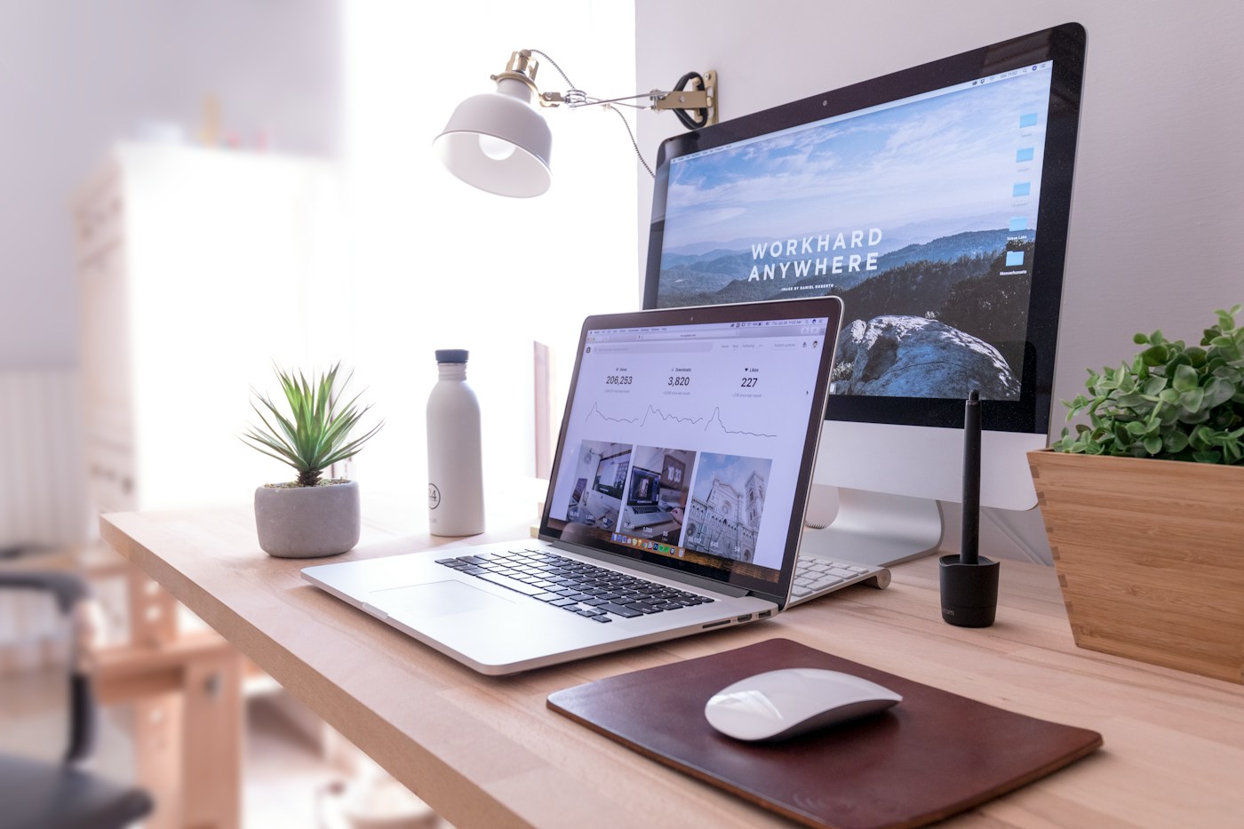 Professional web design workspace with desktop display and laptop